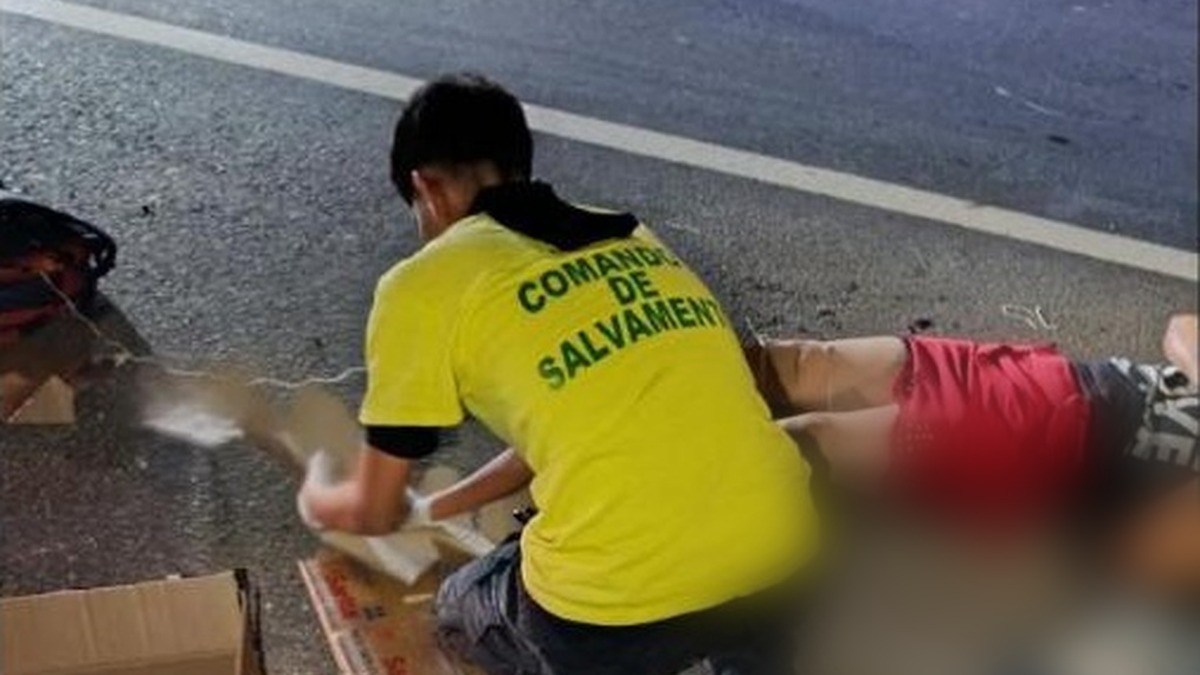 Socorrista de Comandos de Salvamento atiende a una mujer tendida en la carretera de Sonsonate a San Salvador, en Armenia