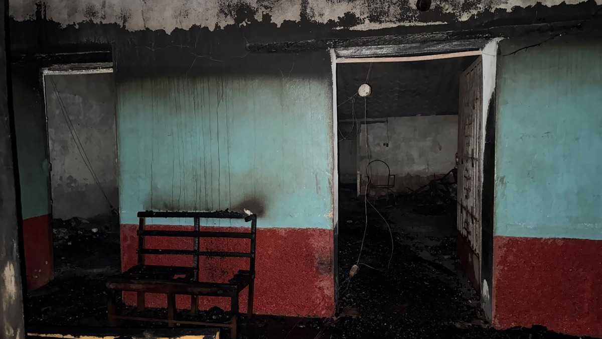 Interior de una vivienda quemada en Ciudad Barrios, con paredes ennegrecidas y una banca carbonizada