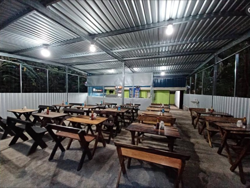 El comedor techado, con mesas y bancas de madera