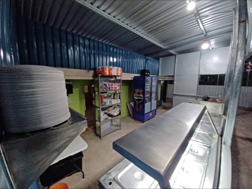 El área de servicio: mostrador de acero, estantería y refrigerador