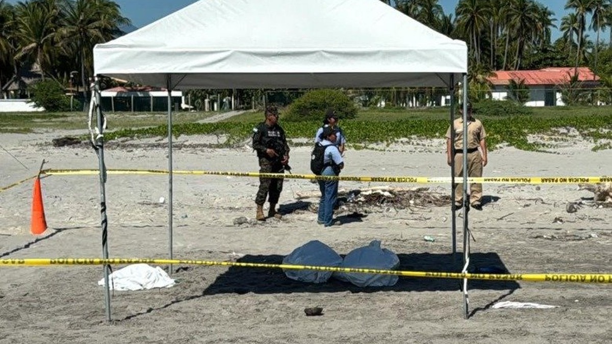 Toldo blanco y cinta policial en la arena de la playa Costa del Sol, con policías y un soldado de pie