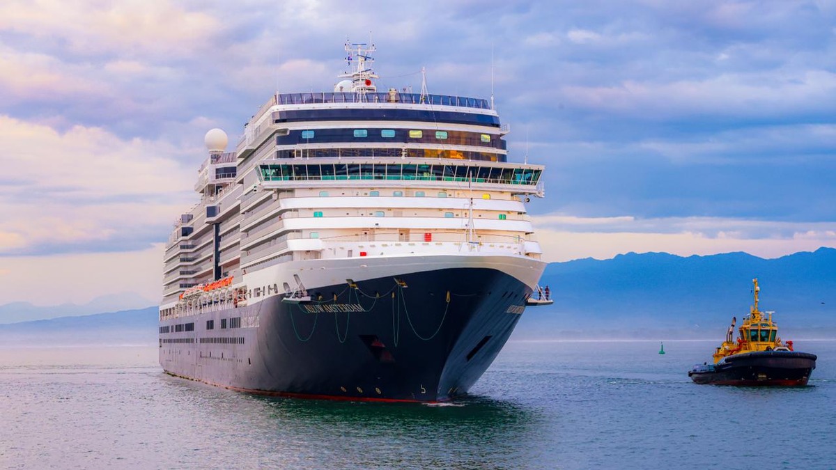 El crucero Nieuw Amsterdam se acerca al puerto de Acajutla acompañado de un remolcador