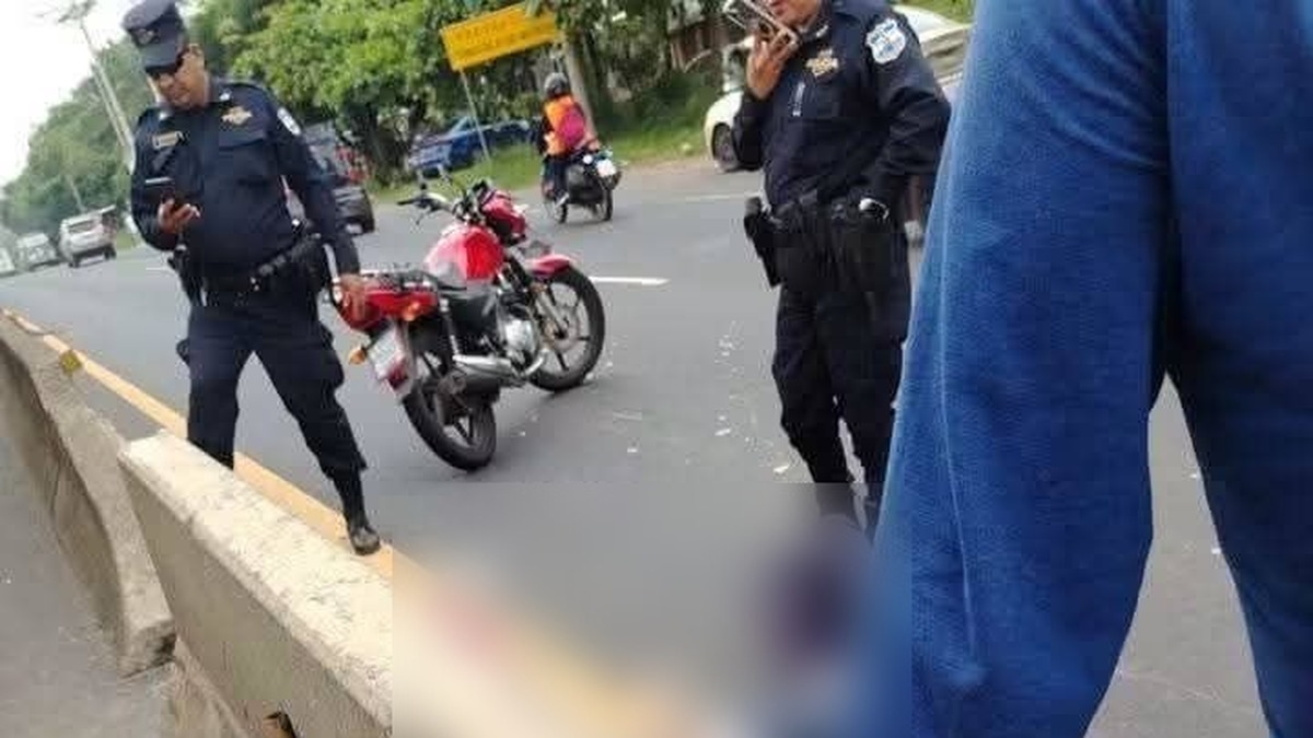 Agentes de la Policía y una motocicleta en la carretera, en el lugar del accidente en Izalco