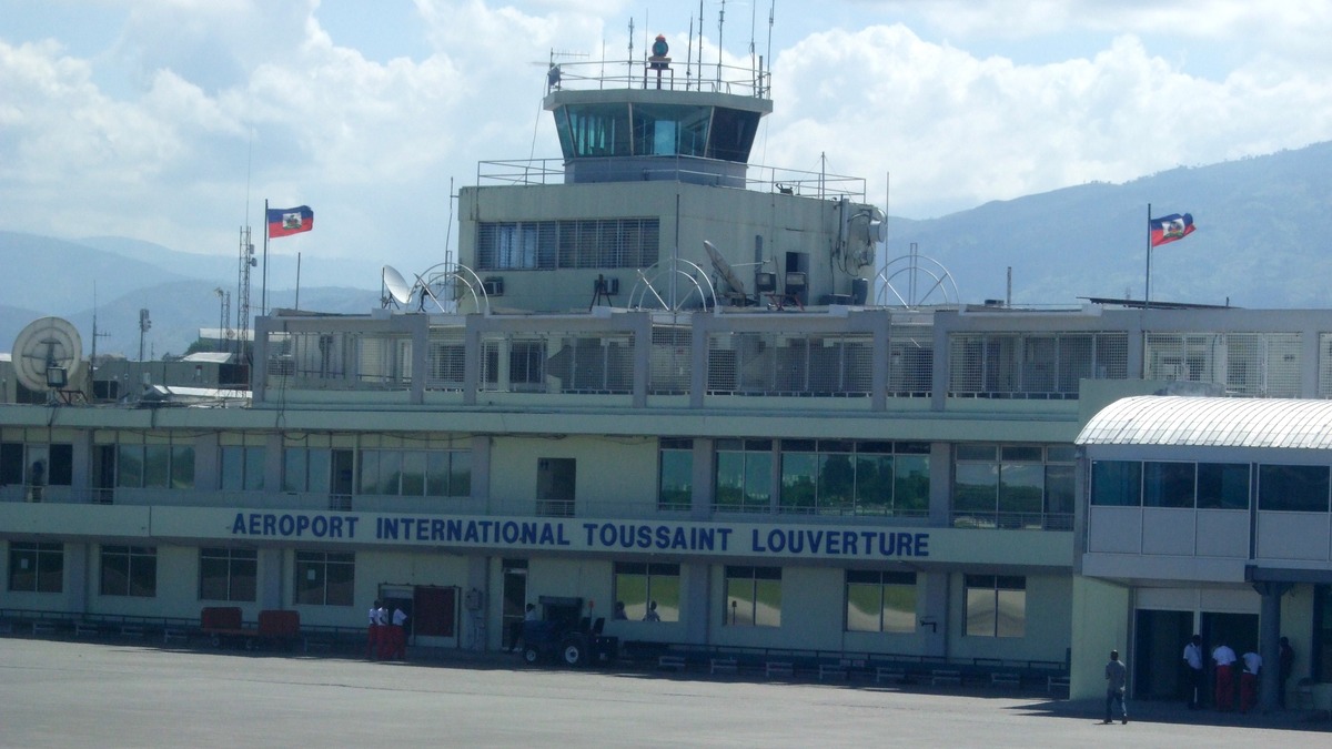 Terminal del aeropuerto internacional Toussaint Louverture de Puerto Príncipe, con su torre de control y banderas de Haití