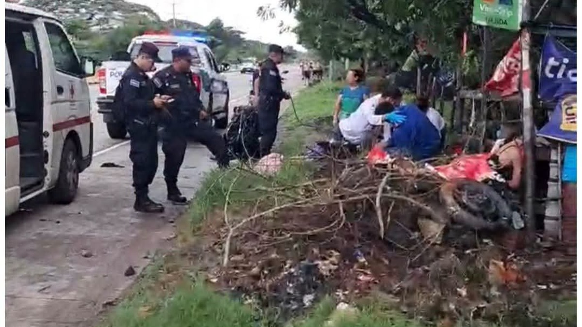 Agentes de la PNC y socorristas de Cruz Roja en la orilla de la carretera de Sonsonate a Acajutla tras un accidente de moto