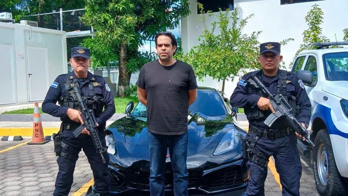 El capturado custodiado por dos agentes de la PNC frente al vehículo deportivo dañado