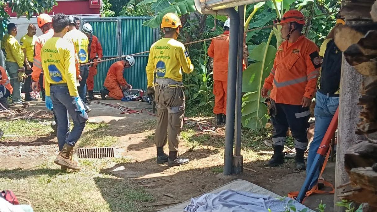 Socorristas de Comandos de Salvamento y del Cuerpo de Bomberos durante las labores de recuperación junto al pozo, en Izalco